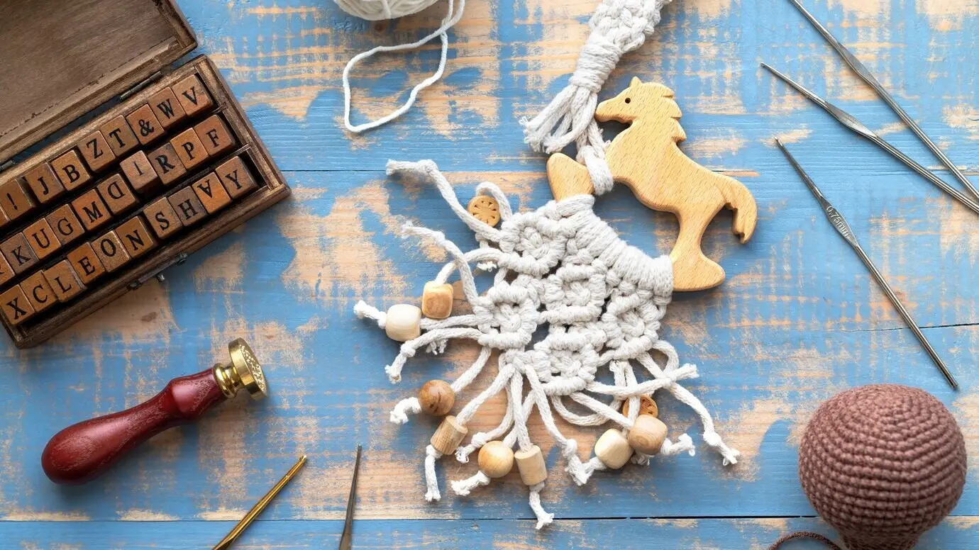 Arbeiten mit Garn, Set aus Holzbuchstaben, handgemachte Dinge, Komposition aus Materialien und Werkzeugen. Draufsicht.