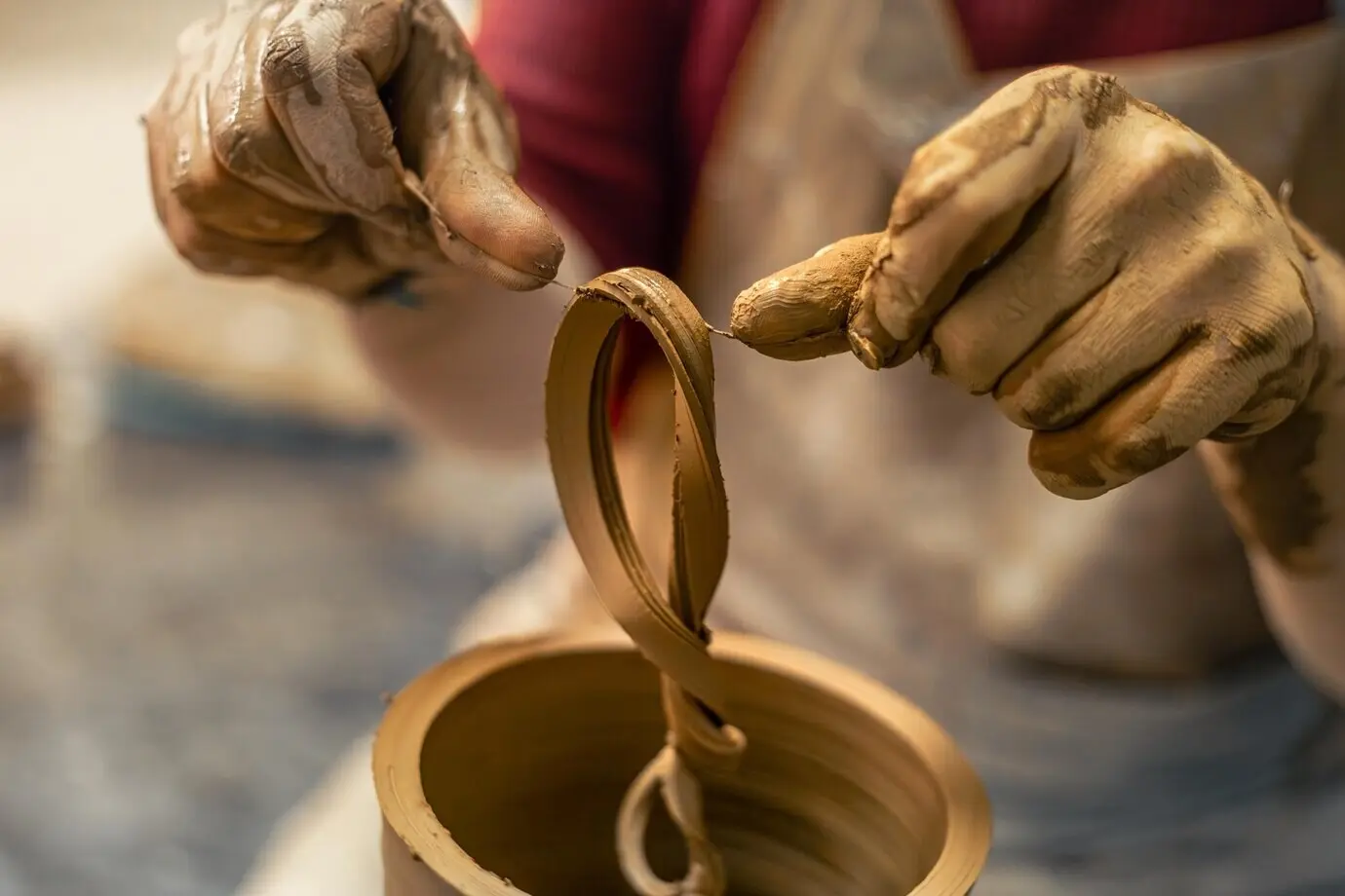 Ein männlicher Töpfer stellt eine Vase her, modelliert Ton und fertigt Keramik.